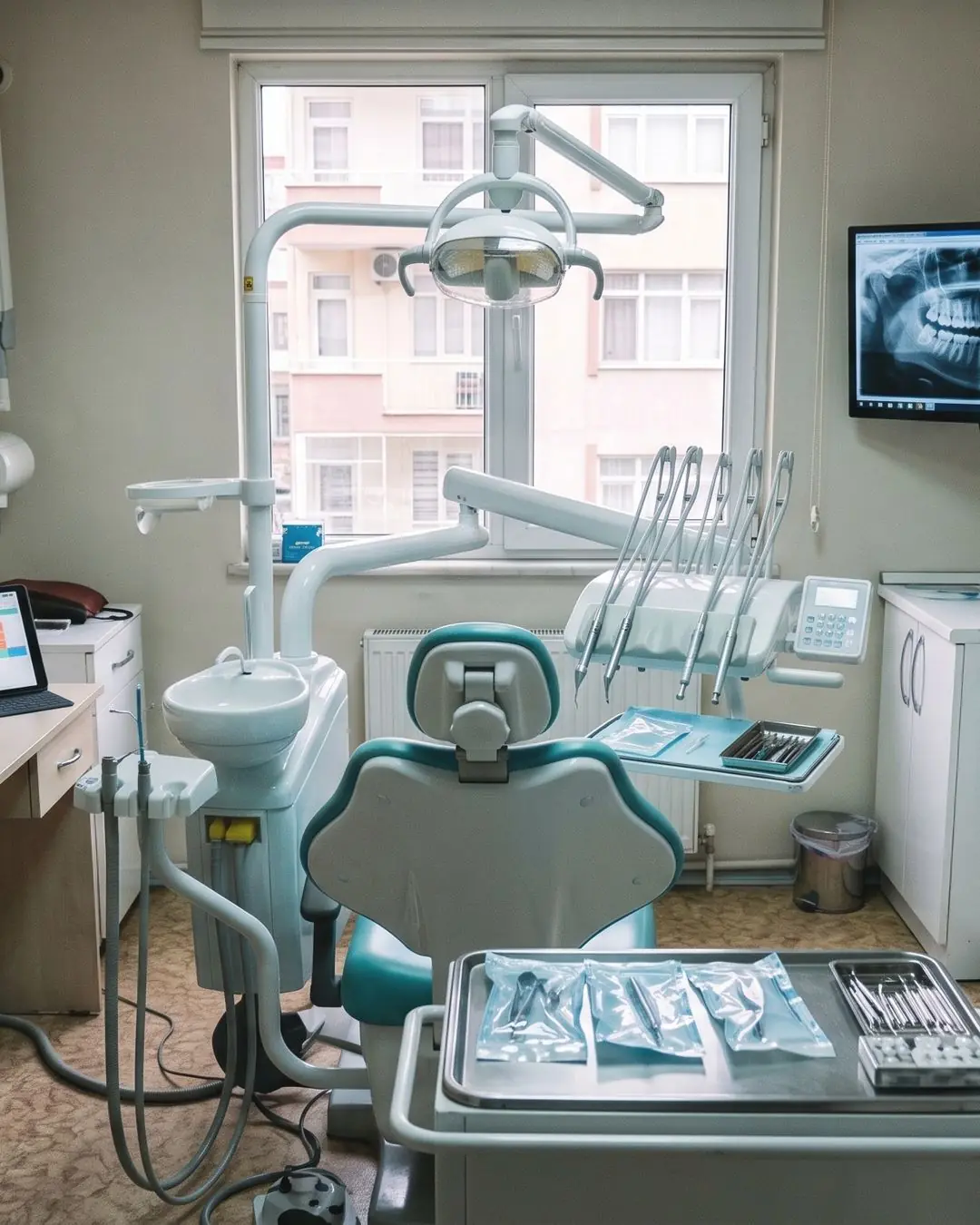 Diş kliniği tedavi odası: diş ünitesi, röntgen ekranı ve tablette randevu takvimi